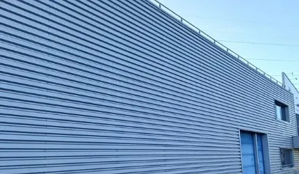 Bardage métallique d’un bâtiment commercial après nettoyage par TTMT